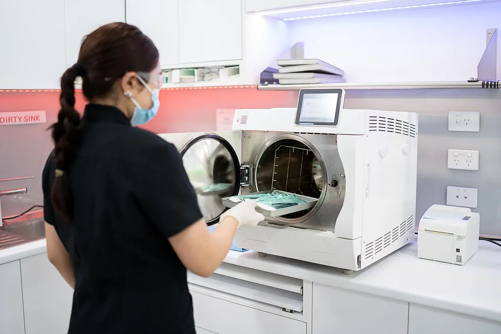 A dental assistant preparing sterilised equipment